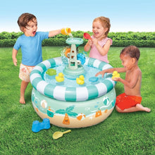 Outdoor splash-and-sand activity table with kids playing at the water sprayer