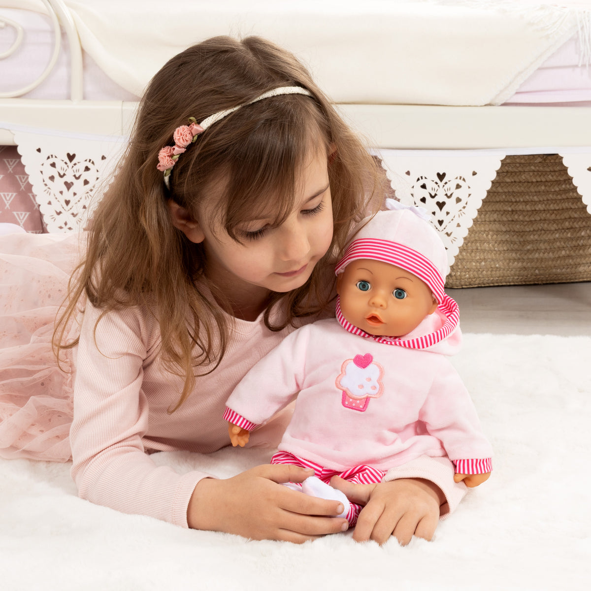 Pink baby doll with cupcake graphic dress, red-and-white striped hat and sleeves