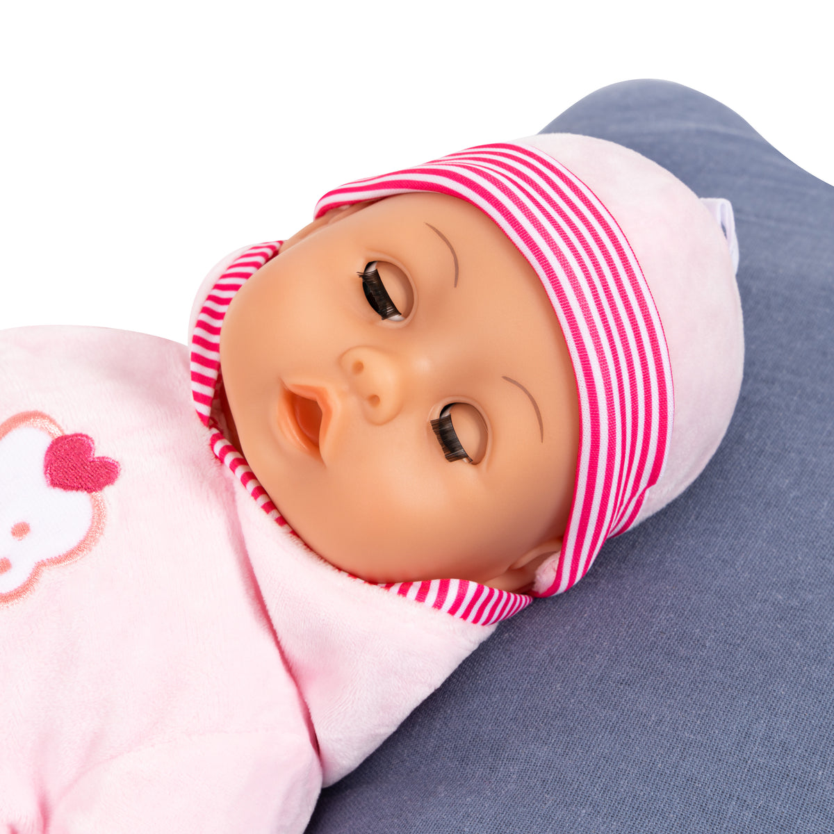 Pink baby doll hood and striped cap, cradled in blue fabric with cupcake patch