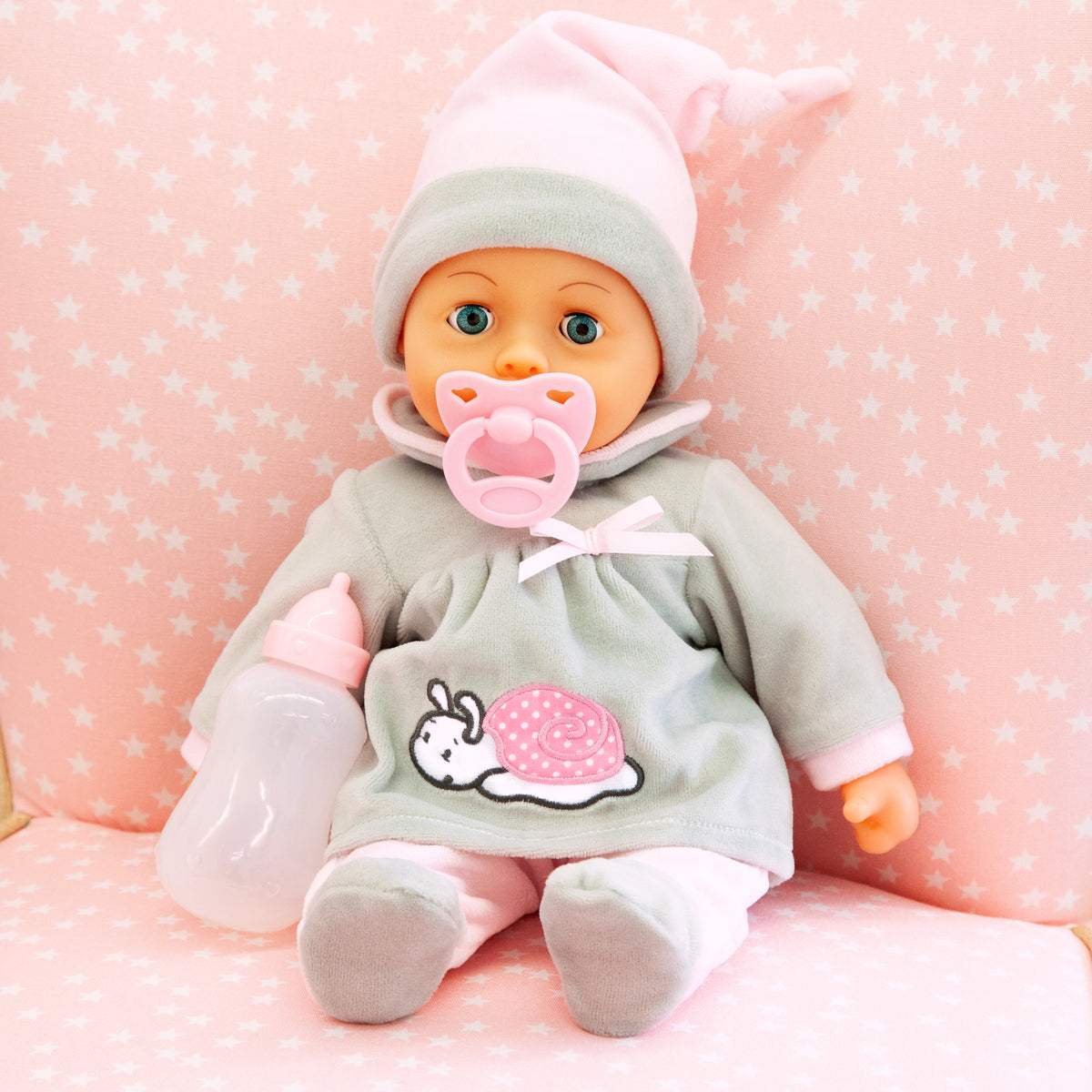 Grey baby doll in hooded outfit with pink pacifier and matching baby bottle