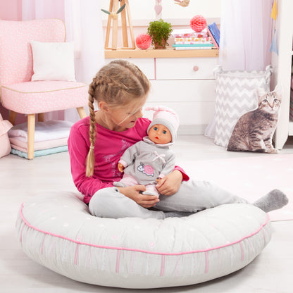 Grey baby doll held by child, grey-and-pink outfit with pink pacifier