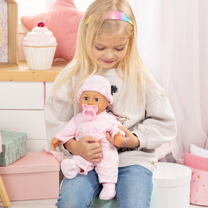 Pink baby doll with frilly hat and pacifier, held while wearing pink striped outfit.