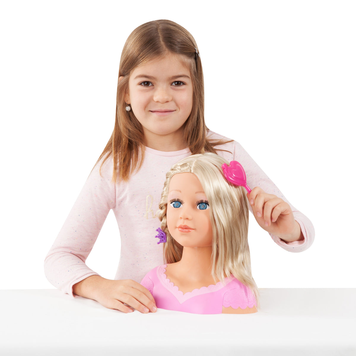 Child holding a blonde doll head with pink hair bow and pink dress top