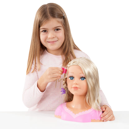 Child adjusting a blonde doll head with pink hair clip and pink dress top