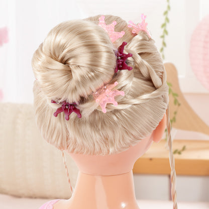 Blonde doll styling head back view with braided updo and pink decorative hair clips.