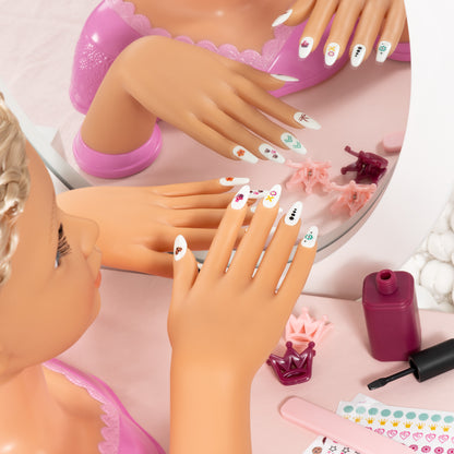Doll hands with long nail decals being applied to a glossy pink manicure styling head.