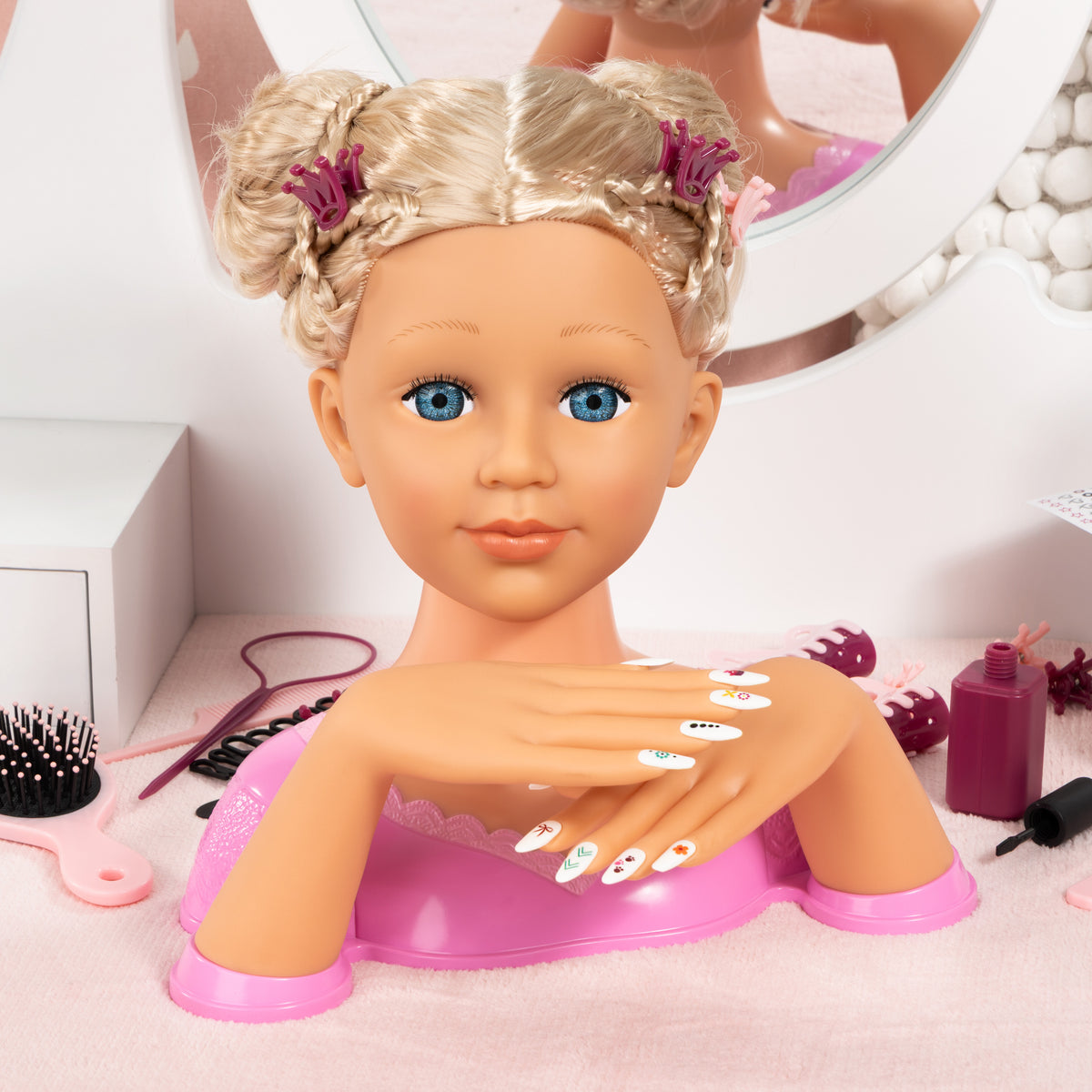 Blonde styling head doll with long hair and magenta top, surrounded by nail tools