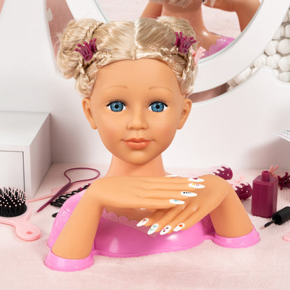 Blonde styling head doll with long hair and magenta top, surrounded by nail tools