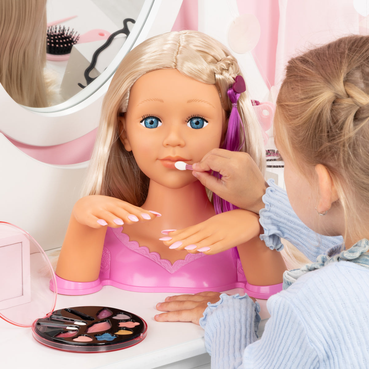 Blonde styling head doll with white nail polish on fingers, child brushing nails