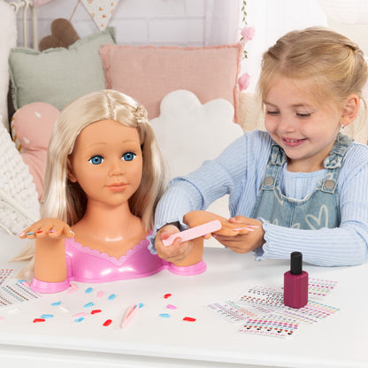 Child applying nail decals to blonde styling head doll with pink manicure tools