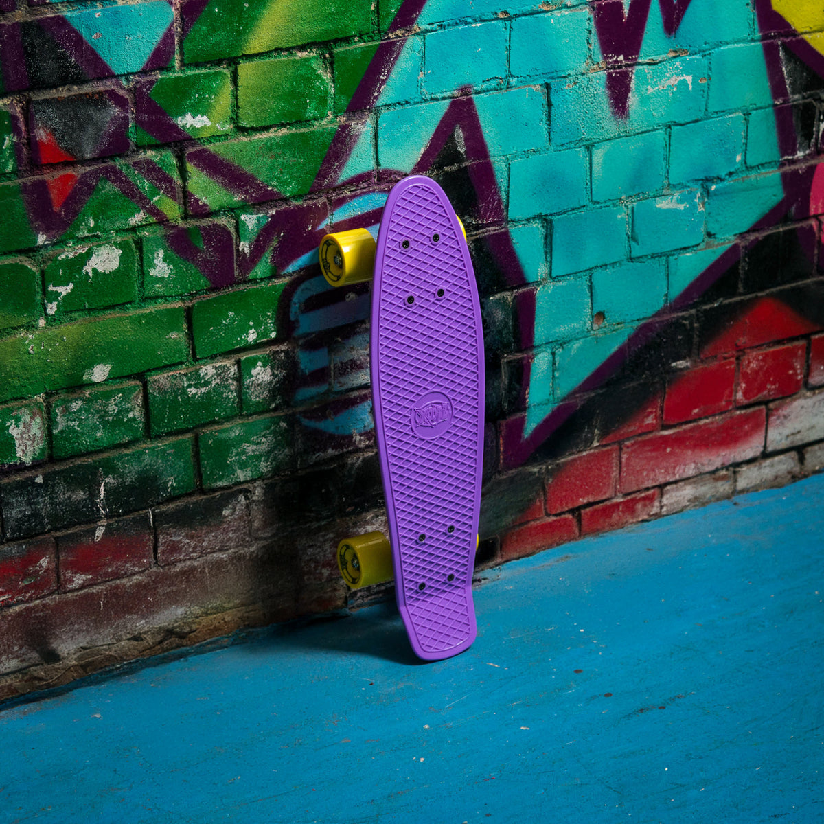 Purple skateboard deck with textured grip and yellow wheels