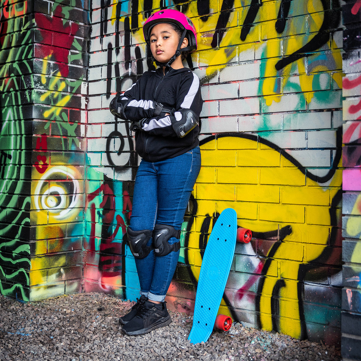 Blue skateboard leaning near a person, orange wheels visible