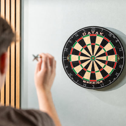 Dayak Warrior dartboard mounted on a wall with a player aiming a throw at the bull.