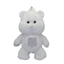 White plush bear figurine with embroidered face and glitter clover belly badge