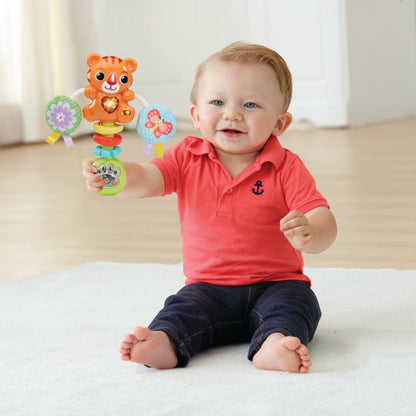 Baby holding orange tiger rattle toy with stacked rings and fabric teether balls