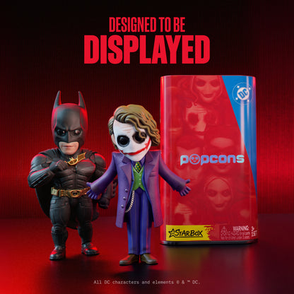 Two DC Heroes mini figures beside red-and-blue Popcorns blind box canister