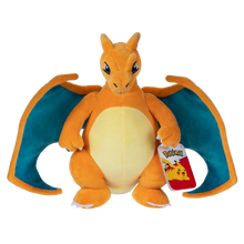 Pokemon Charizard plush with orange body, cream belly, teal wings, and attached character tag