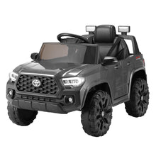 Grey kids electric ride-on Toyota Tacoma truck with grille, headlights, and chunky tires
