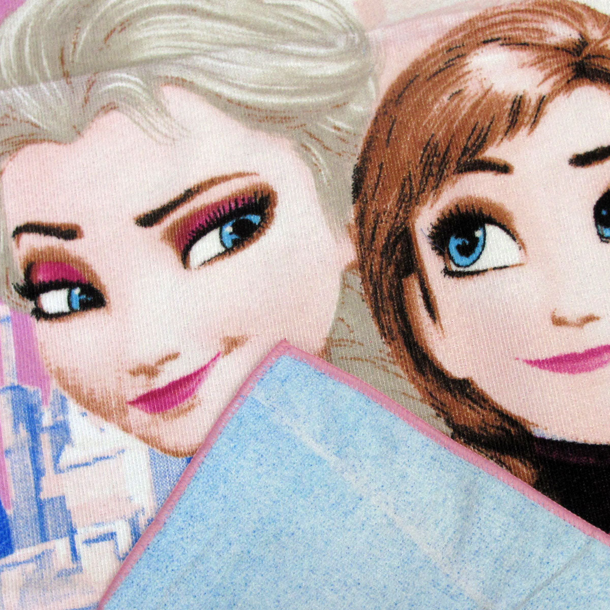 Close-up kids towel print featuring Elsa and Anna faces with icy blue fabric