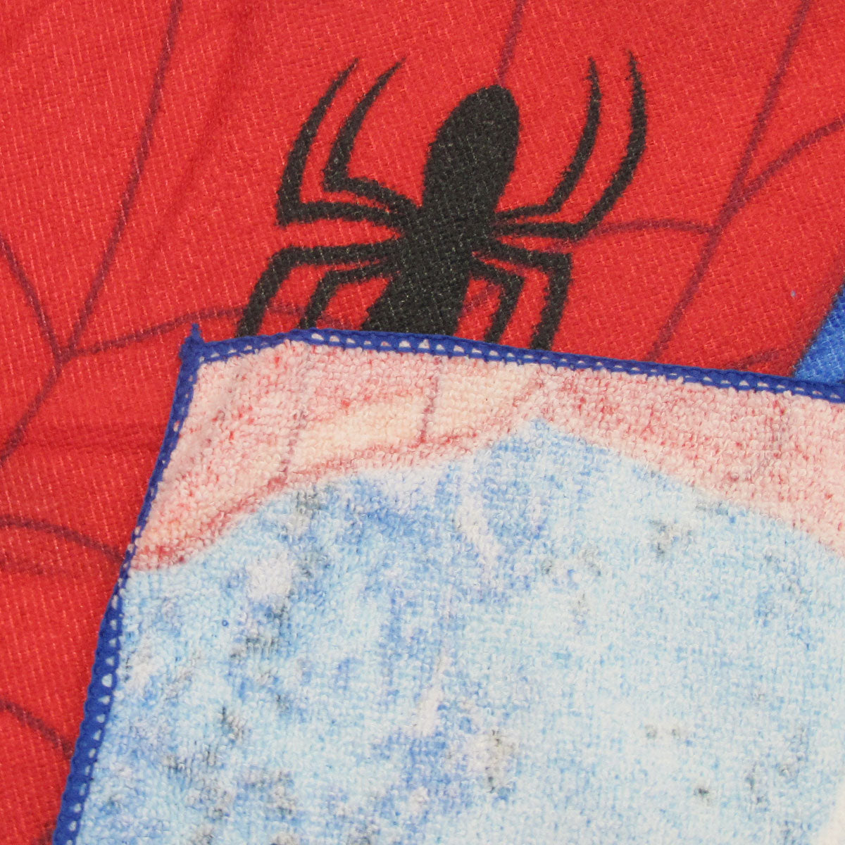 Microfiber beach towel close-up with red spider print and light blue pile