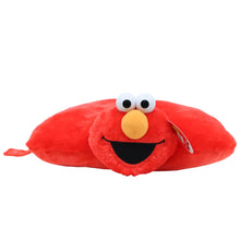 Red Elmo plush pillow lying sideways, yellow nose, black smile and stitched eyes