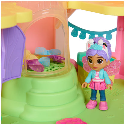Fairy dollhouse interior with butterfly-wing doll figure by green wall and arched window